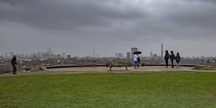People stand on primrose hill as storm clouds gather