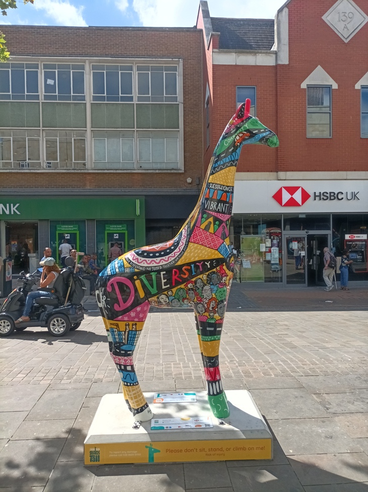 A colourful giraffe sculpture with 'diversity' written on it