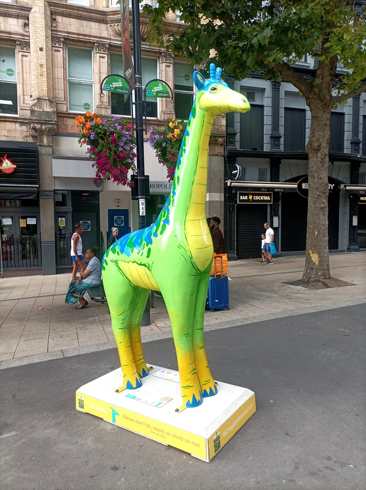 A giraffe painted like a dinosaur