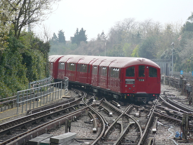 A red 1930s tube train on the track
