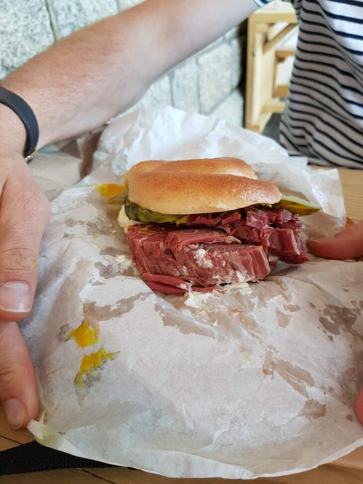 A homemade bagel is stuffed full with chunky salt beef and gherkins. 