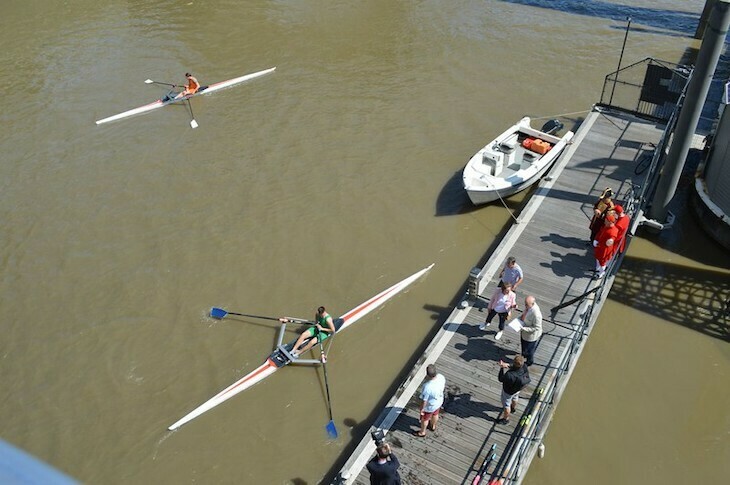 In the river thames, a rower approaches a pier