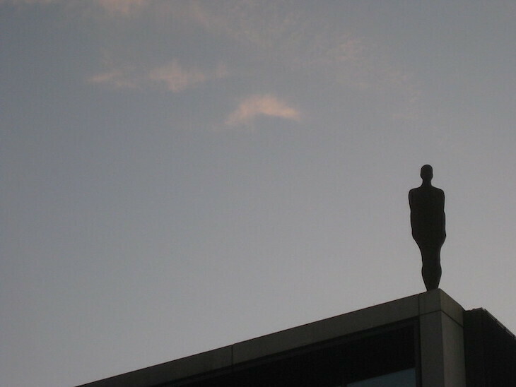 Antony Gromley sculpture of a human form standing on a building
