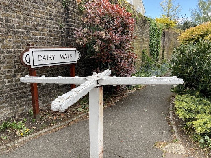 Free Things To Do In London:  A white turnstile guards the entrance to a passage known as Dairy Walk