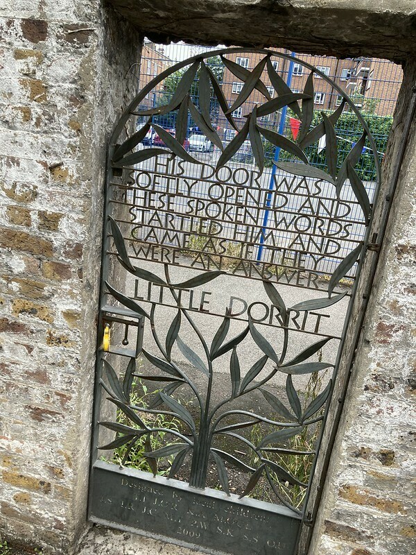 Literary gate: a wrought iron gate in a brick wall. It has a quotation from little Dorrit on it