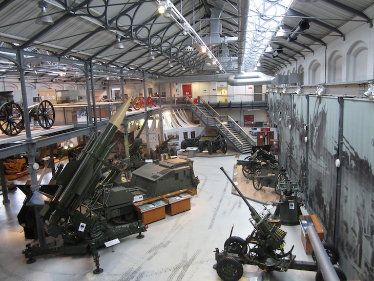 The interior of Firepower - a light, warehouse style room with various guns, cannons and carriages on display across two levels.