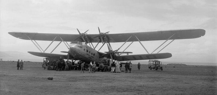 A large bi-plane on the ground, surrounded by people