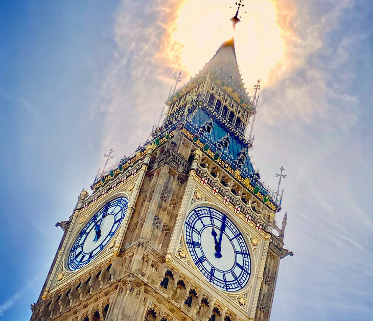Big Ben clock tower with the sun behind its pinnacle