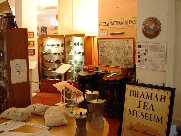 The interior of the Bramah Tea & Coffee Museum. Exhibits include a map of the tea trade, a cabinet of teapots, and some photographs