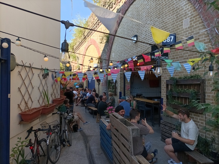 Best taprooms London: People drinking by railway arches with bunting