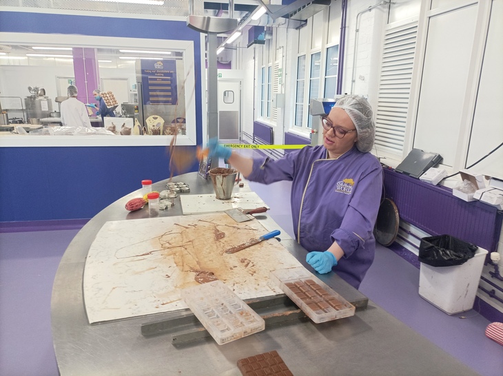 Things to do in Birmingham: A person in purple overalls flipping up chocolate with a spatula