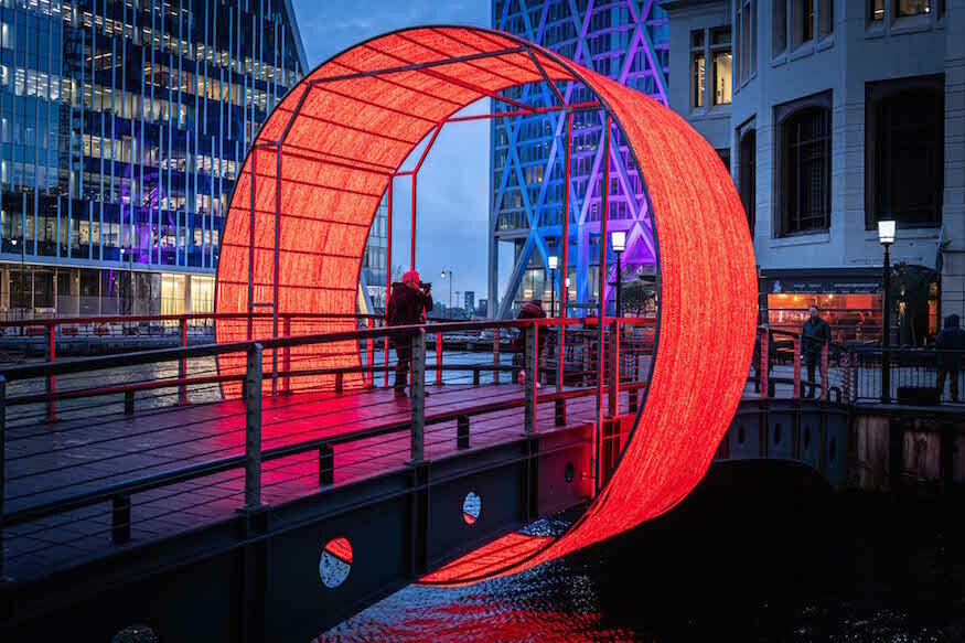 A large glowing red hoop encircling a pedestrian bridge