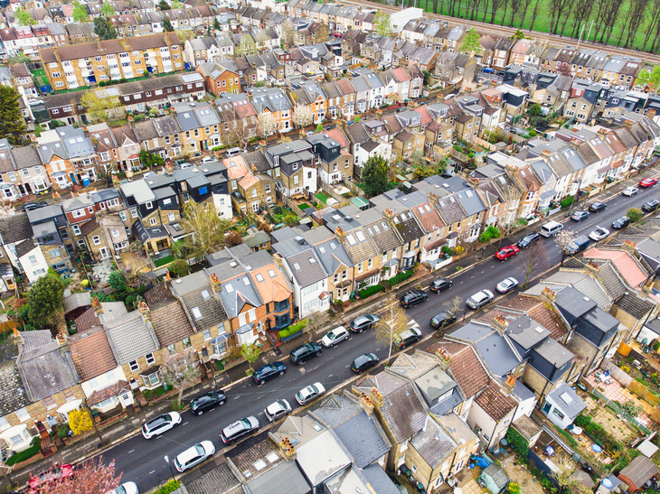 Aerial shot of cars parked up in two lines along a residential streets