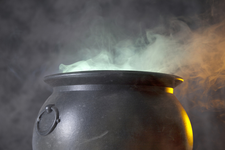 A cauldron bubbling with green smoke