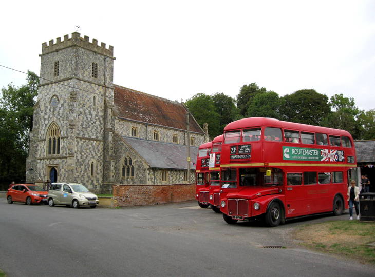 Imberbus 2023: a few red buses parked outside a country church