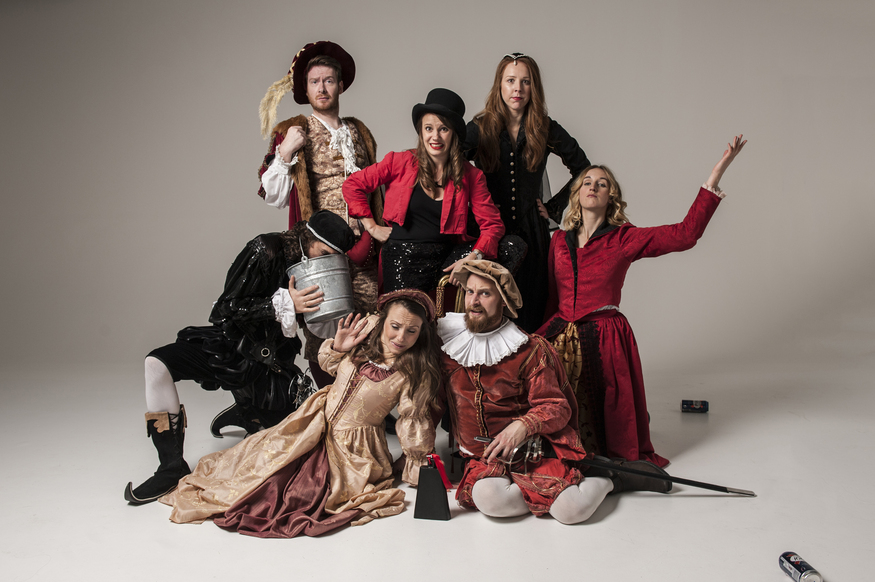 Actors dressed in Shakespearian garb posing for the camera - one of them has their head in a bucket
