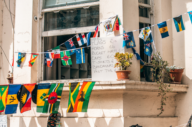 A price list for flags, horns, caps etc on a window ledge decorated with flags