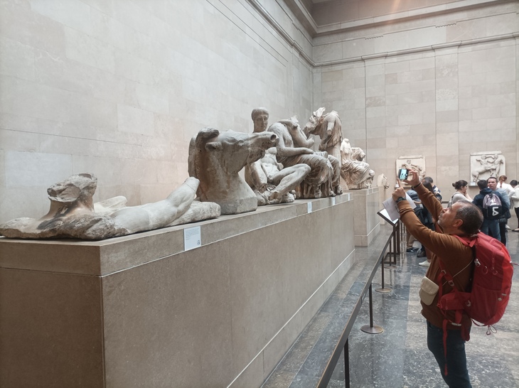 Visit the British Museum: A man takes a photo of sculptures