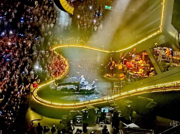 Things to do in Birmingham: Elton John performing on an arena stage glowing yellow