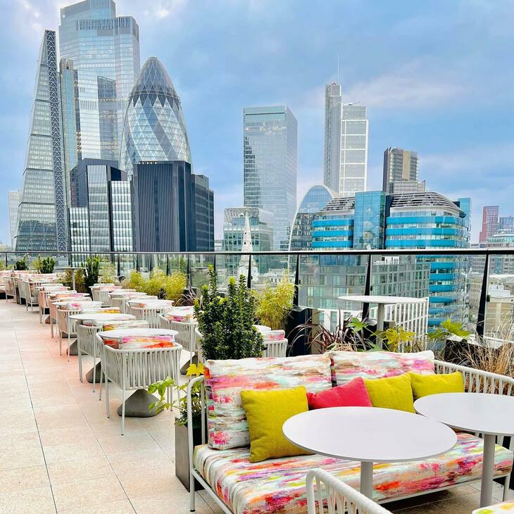A stunning city view from a terrace with floral chairs