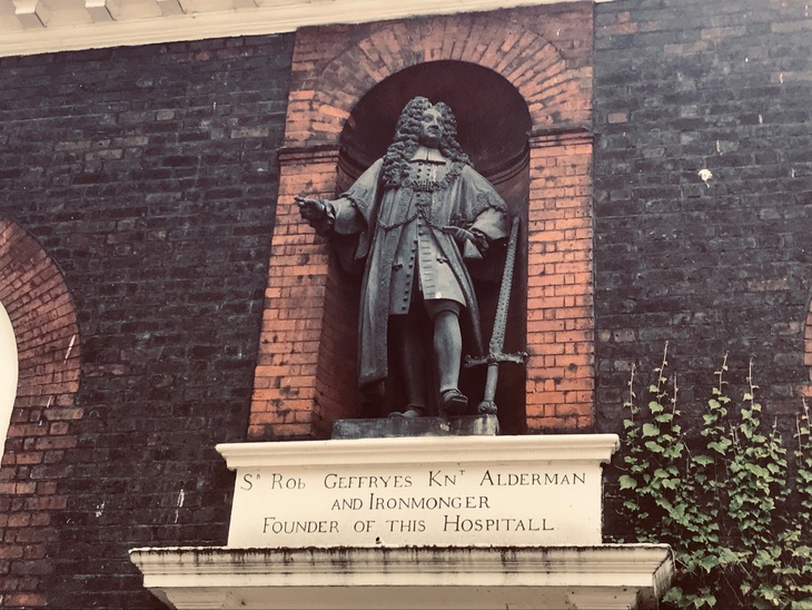 A statue of a bewigged man standing in an alcove
