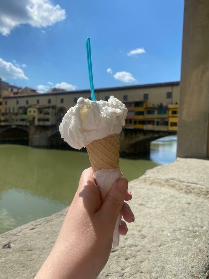 A gelato being held in front of the Ponte Vecchio