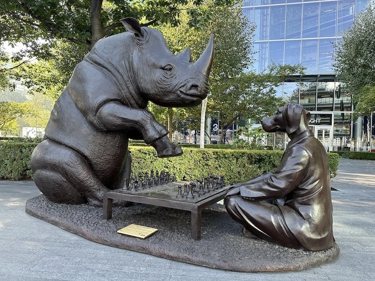 Sculpture of a rhino playing chess with a dog