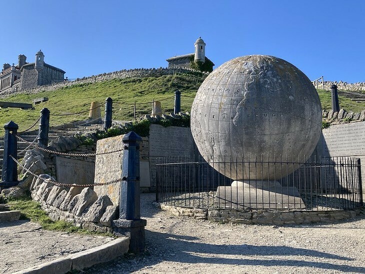 A large globe of the world flanked by bollards in Durlston, Dorset