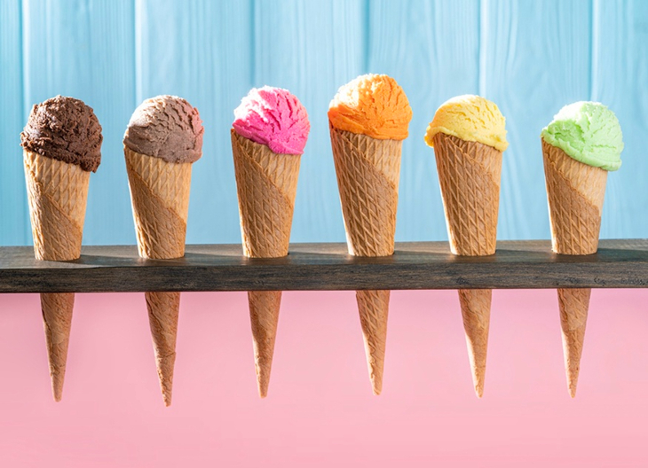A row of colourful ice cream cones - with pastel pink and blue background