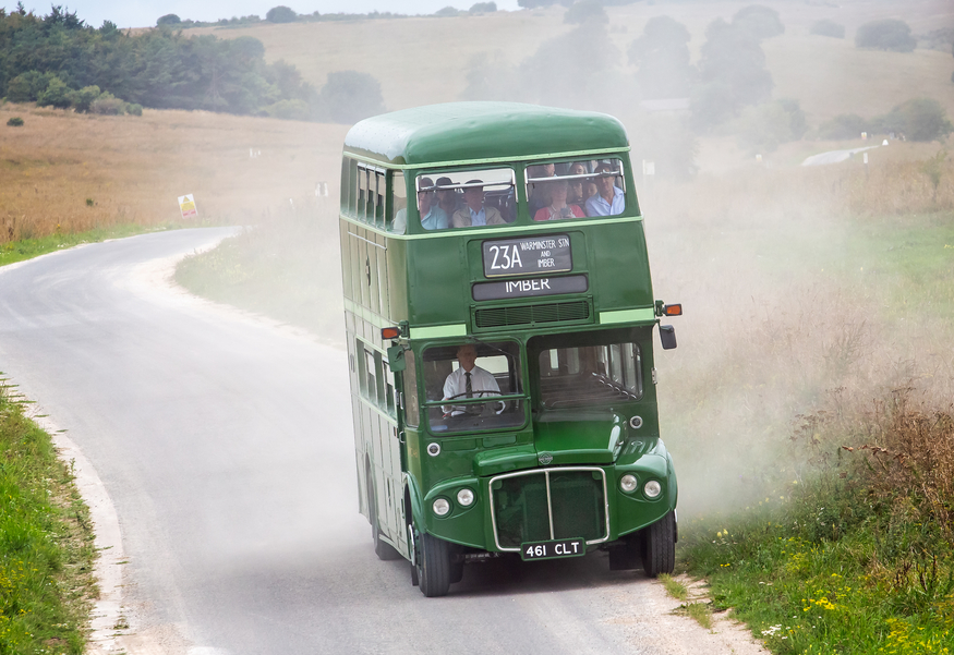 Imberbus 2023: a green double decker driving down a country lane in a cloud of dust