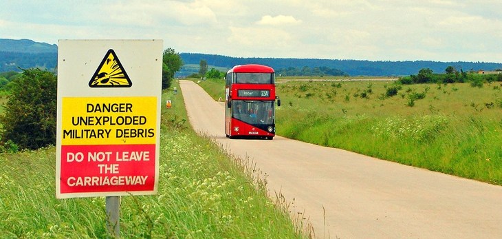 Imberbus 2023: a modern Routemaster driving down a country road - a sign in the foreground warns of unexploded debris