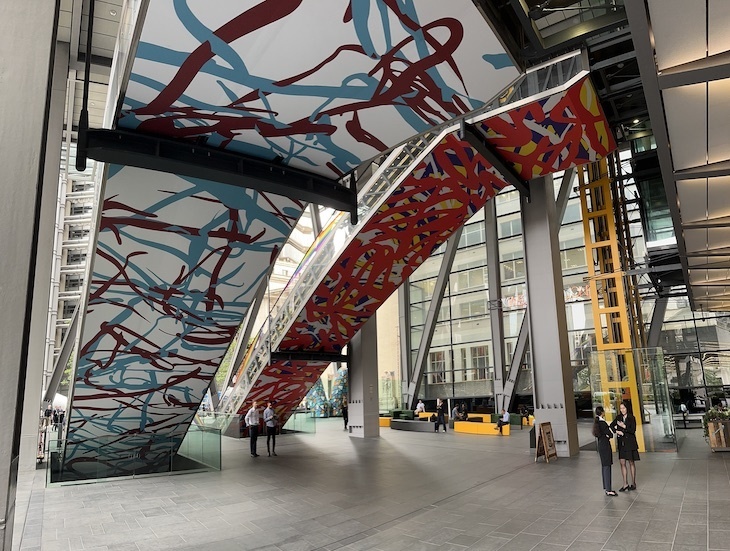 The escalators of the Leadenhall Building (Cheesegrater) seen from beneath, with colourful wraps on both
