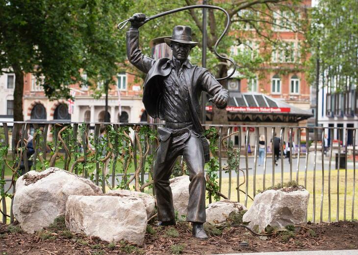 A bronze Indiana Jones statue featuring hat, leather jacket and bullwhip