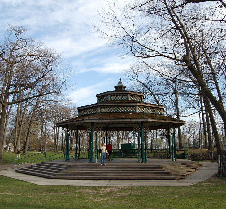 A bandstand in a park, surrounded by trees without their leaves in autumn or winter.