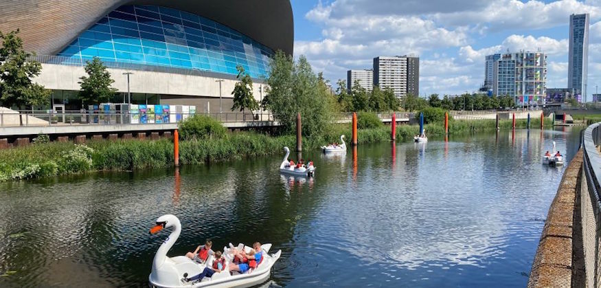 Swan pedalo boats on a river in the Queen Elizabeth Olympic Park, in front of the Aquatics Centre