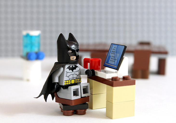 A lego batman using a computer