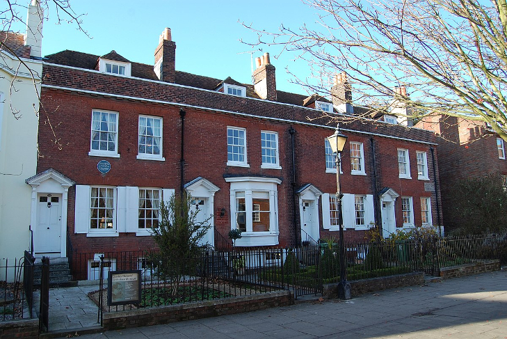 Literary days out: a terrace of four redbrick townhouses-  the one one the left has a blue plaque mounted on the front.