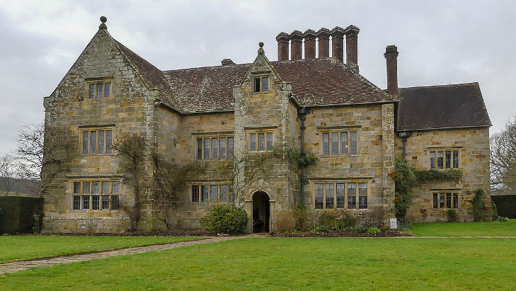 Literary days out: an elegant Jacobean manor house with several chimneys, surrounded by a neat lawn.