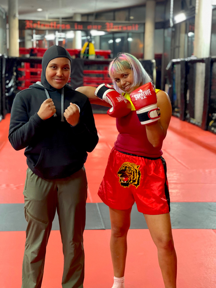Two women in boxing gear posing for the camera