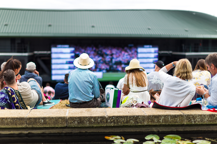How to queue for Wimbledon:  Spectators sitting on Murray Mound, watching the big screen