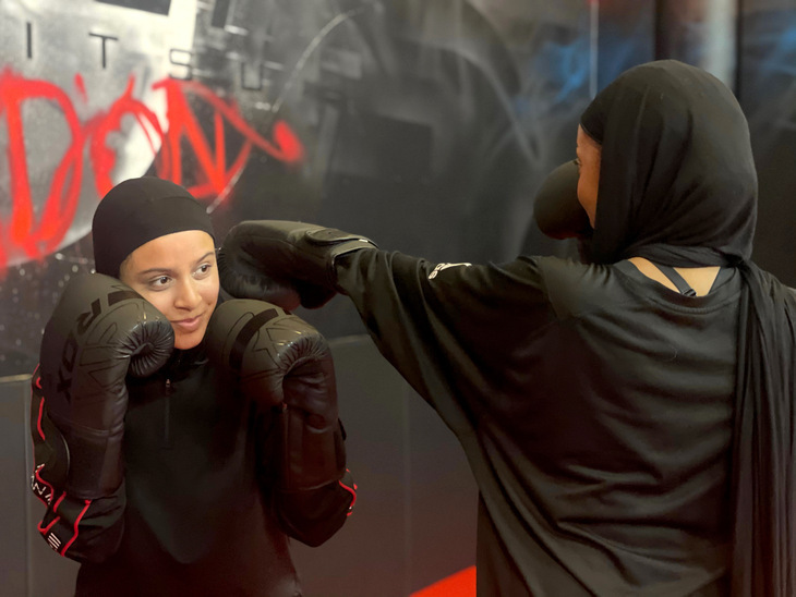 Two women in black throw some boxing moves