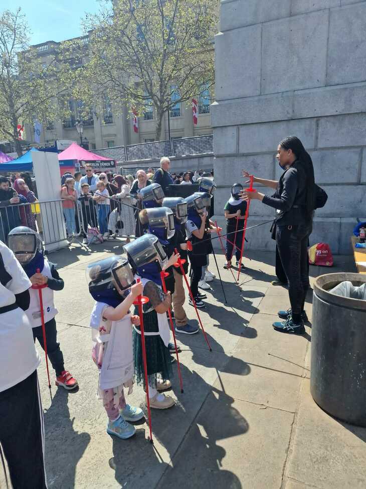 A line of young girls in fencing kit