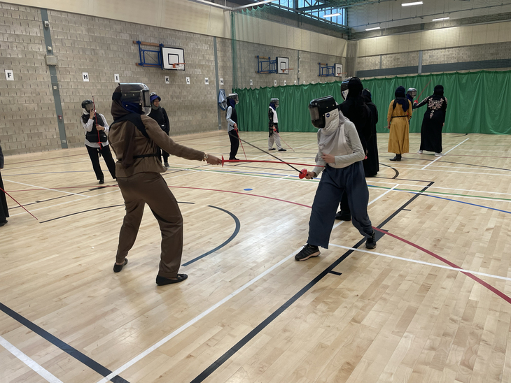 Young women fencing in a gym