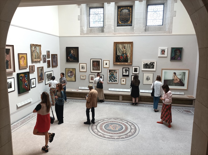 People perusing art, as viewed through an archway