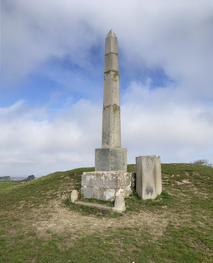 An obelisk alone on a grassy hillside above swanage