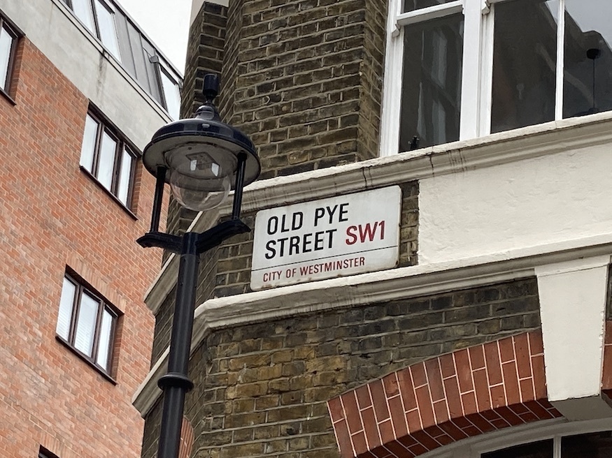 A street sign saying Old Pye Yard with lamp