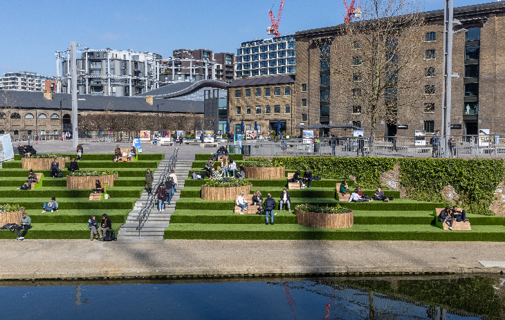Open air cinema in London: people sitting on the canalside steps next to Granary Square