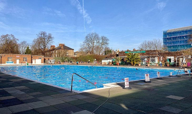 Looking across the outdoor pool at Brockwell Lido in Herne Hill, with houses and flats visible beyond the lido
