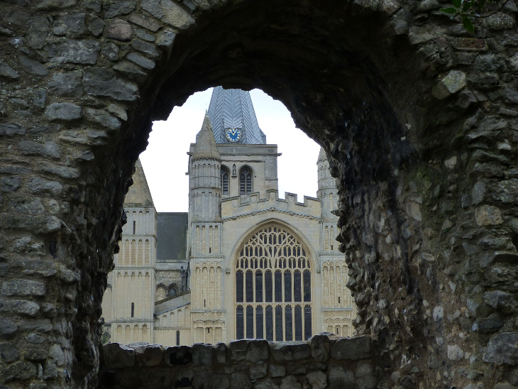 Looking through a gap in a stone wall towards Rochester Cathedral