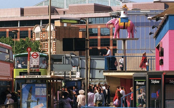A bustling Elephant and Castle, with a bright pink elephant mascot on a pole outside the shopping centre